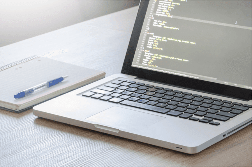 Laptop showing code for Web Design Farnham
