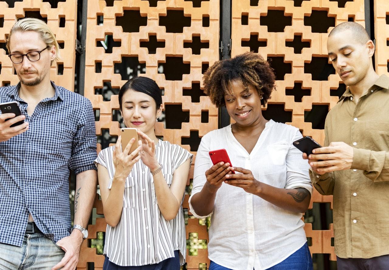 People looking at their phones, engaging with content from our social media company in Surrey