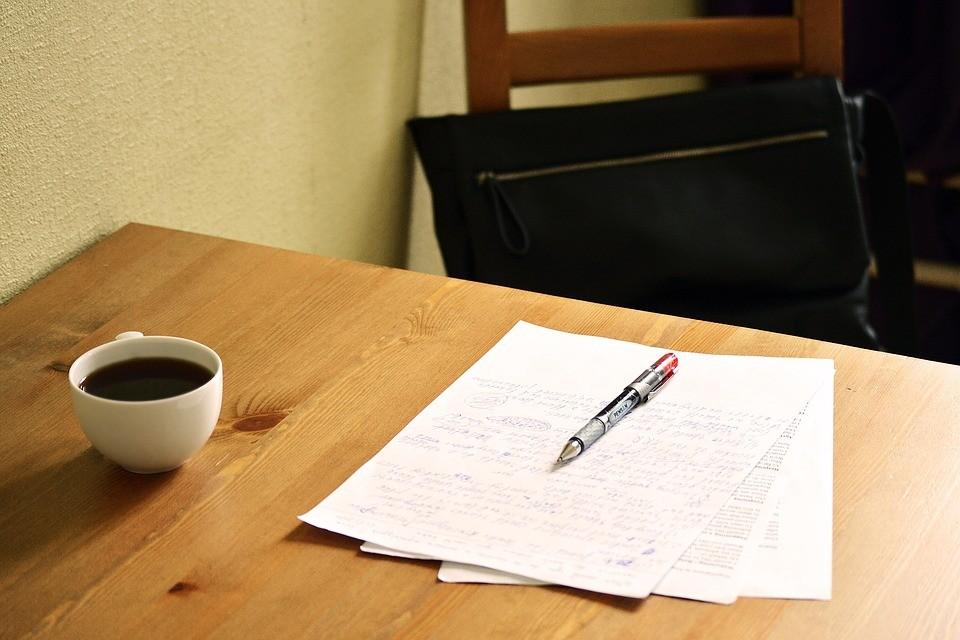 A stack of papers on a desk being corrected | Surrey marketing agency