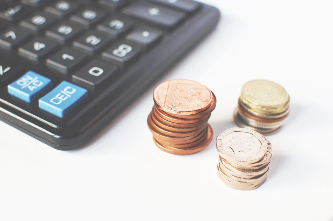 Stacks of UK coins next to a calculator | Marketing in Guildford