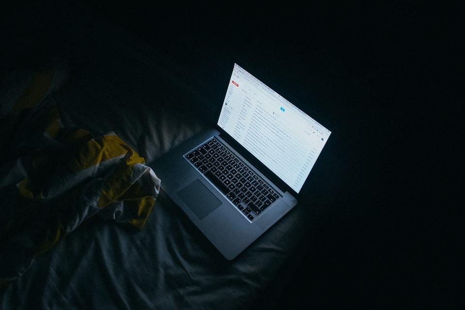 An image of a laptop with Gmail open in a dark room | Email Marketing Surrey | Thunderbolt
