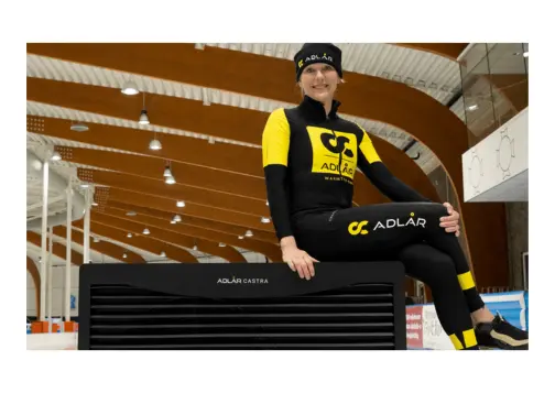 Woman in Adlår branded outfit sat atop a heat pump